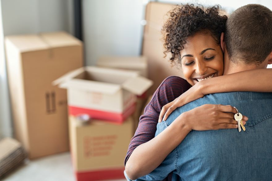  couple hugging surrounded by packing boxes